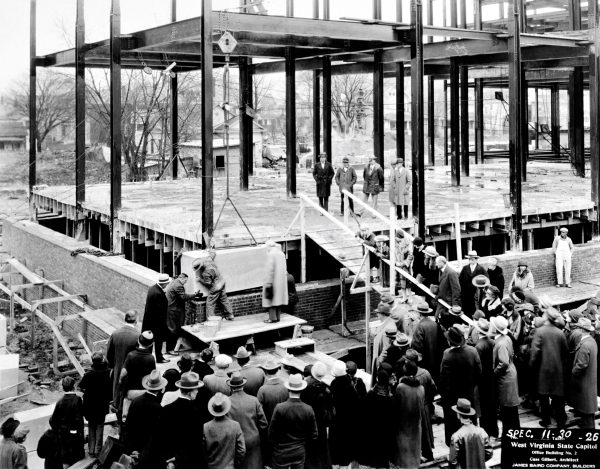 Image of construction workers laying cornerstone of East Wing of Capitol Complex. 